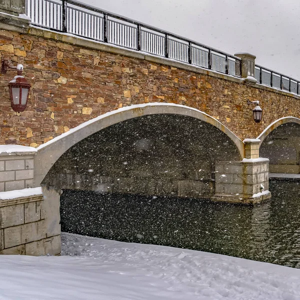 Puente cuadrado sobre el agua ondulada del lago Oquirrh con la costa blanca y nevada — Foto de Stock