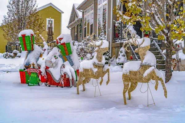 Trineo con regalos y decoración de Navidad de renos en un patio cubierto de nieve en el amanecer — Foto de Stock