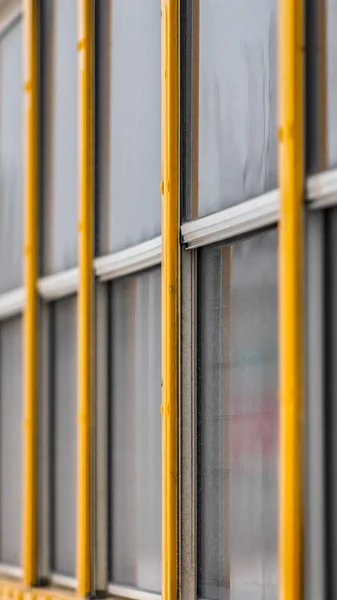 Vista exterior vertical clara de un autobús escolar amarillo con un primer plano en las ventanas de cristal — Foto de Stock