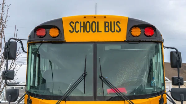 Wyczyść widok z przodu Panorama żółtego autobusu szkolnego z domów i pochmurne niebo w tle — Zdjęcie stockowe