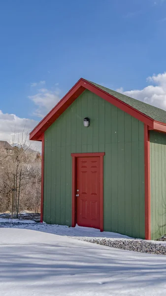 Exterior vertical claro de un cobertizo de almacenamiento de madera construido en un suelo cubierto de nieve en invierno — Foto de Stock