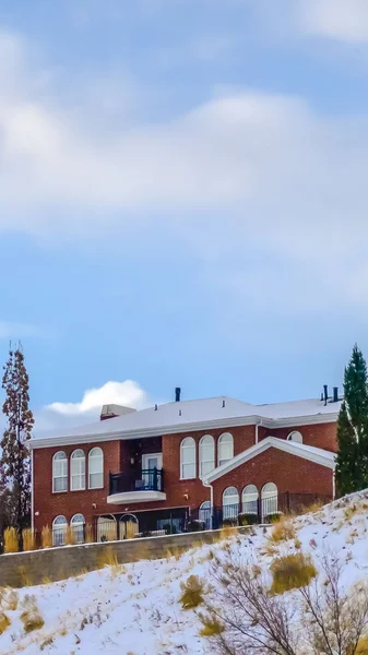 Borrar casas verticales en la colina nevada contra el cielo con nubes hinchadas — Foto de Stock