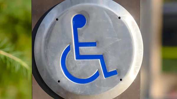 Clear Panorama Close up of a Disabled Sign engraved on a circular metal viewed on a sunny day — Stock Photo, Image