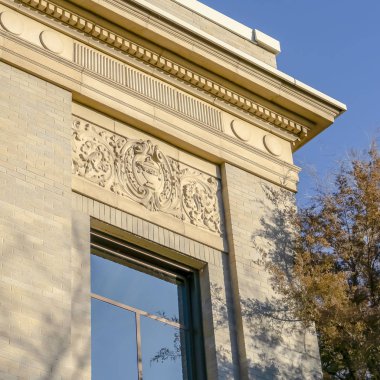 Güneşli bir günde berrak mavi gökyüzünü yansıtan cam pencereleri olan Clear Square Binası