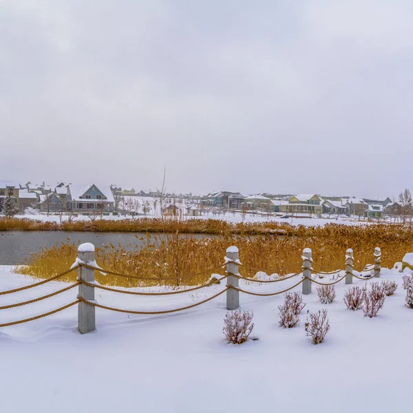 Clear Square Clubhouse con vistas al lago y casas contra el cielo nublado en un día de invierno helado — Foto de Stock