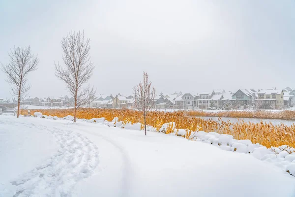 Sendero en la nieve polvorienta a lo largo del lago Oquirrh con vista a las casas y el vasto cielo — Foto de Stock
