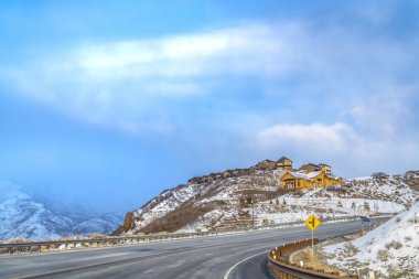Sakin bulutlu mavi gökyüzüne karşı karla kaplı bir dağın manzara kış manzarası