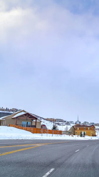 Vertical Paved road curving through a mountain blanketed with snow in winter — Stock Photo, Image