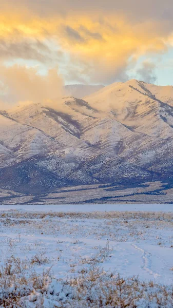 Montaña majestuosa vertical más allá del terreno cubierto de hierba con nieve en invierno — Foto de Stock