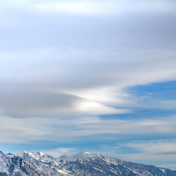 Відкритий квадрат з вражаючою горою з нерівними схилами під величезним синім небом з хмарами — стокове фото