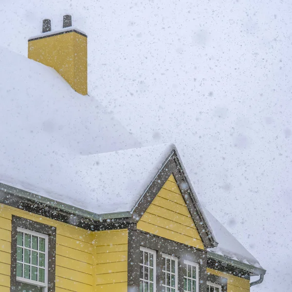 Nieve cuadrada cayendo sobre una casa amarilla en Daybreak Utah — Foto de Stock