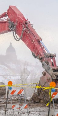 Kışın çamurlu bir dağ yolunda sarı bant ile Dikey Ekskavatör ve barikatlar