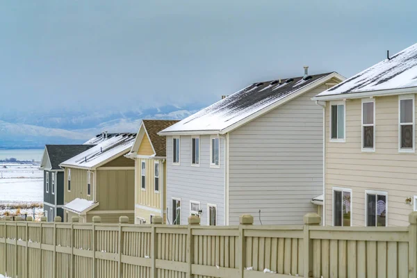 Exterior of homes inside a wooden fence viewed during winter season