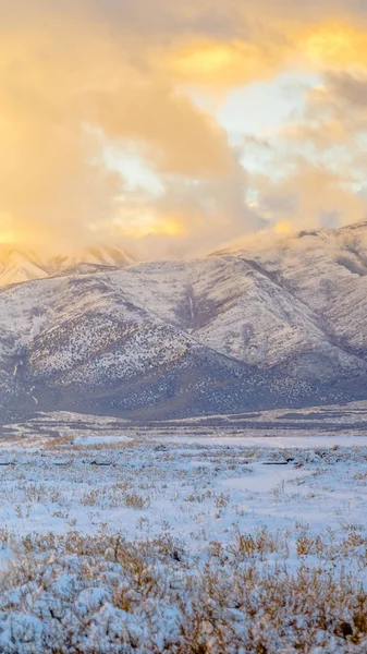 Чистая вертикальная величественная гора за травянистой местностью, покрытой снегом зимой — стоковое фото