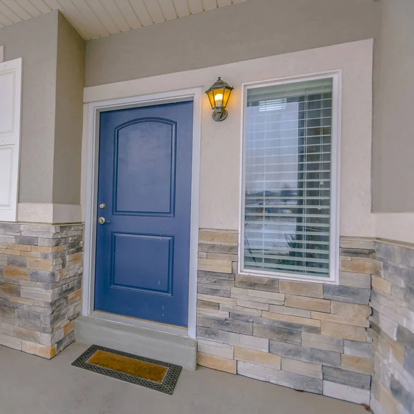Квадратный экстерьер дома с синей деревянной входной дверью и стеклянными окнами — стоковое фото
