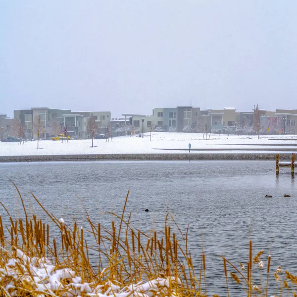 Clear Square Buildings against sky on a snow covered landscape beyond the lake in winter