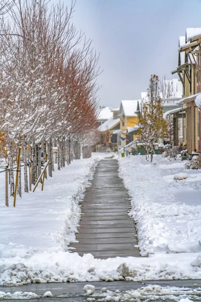 Holzweg zwischen Bäumen und Häusern bei Tagesanbruch utah im Winter gesehen — Stockfoto