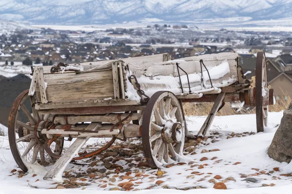 Oude houten wagon met kettingen en roestige wielen bestrooit met sneeuw in de winter — Stockfoto