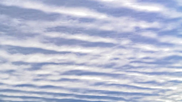 Panorama Defocused view of a boundless blue sky filled with white puffy clouds — Stock Photo, Image