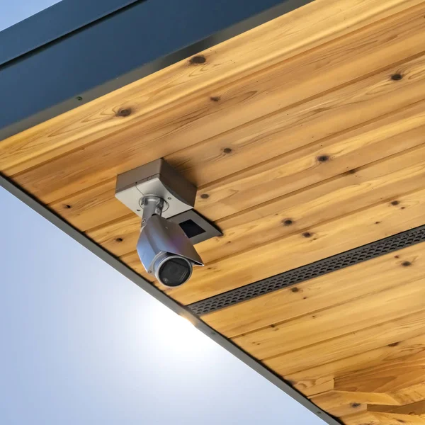 Square Home with security camera installed on the wooden underside of its roof — Stock Photo, Image