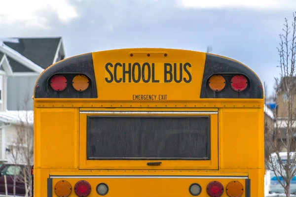 Close up of the rear of a school bus with a window and several signal lights