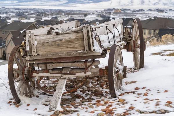 Verweerde houten wagon met kettingen en roestig wiel bekeken in de winter — Stockfoto