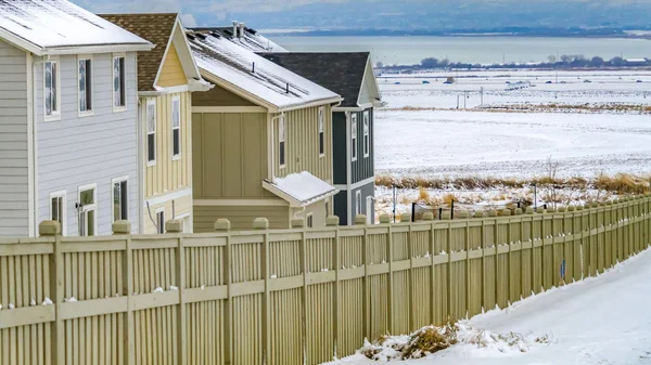 Clear Panorama Casas com uma cerca de madeira cercada por uma vasta paisagem revestida de neve — Fotografia de Stock