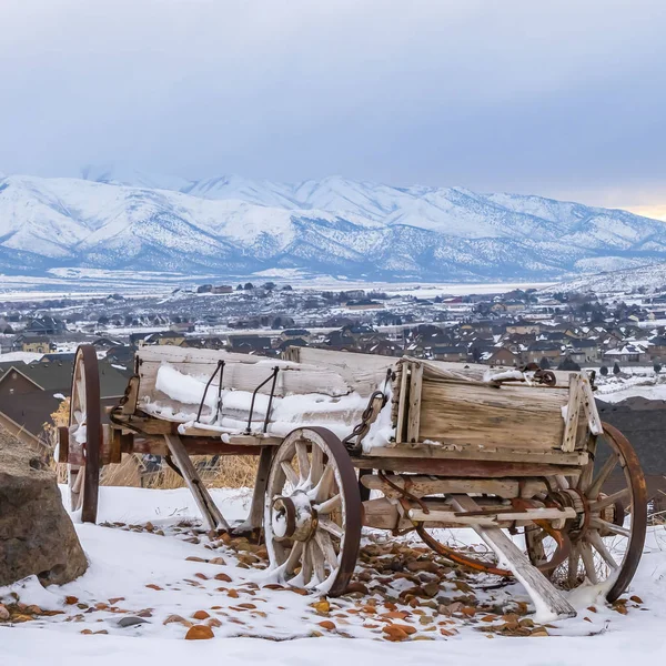 Квадратний похмурий дерев'яний візок і величезні скелі на вершині пагорба зі снігом взимку — стокове фото