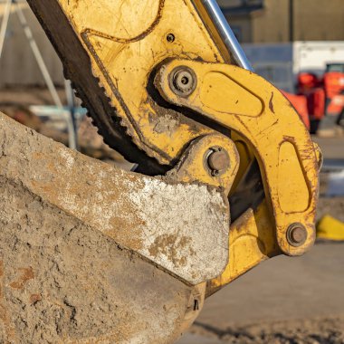 Berrak Kare Güneşli bir günde bir şantiyede görüntülenen sarı bir ekskavatör kova