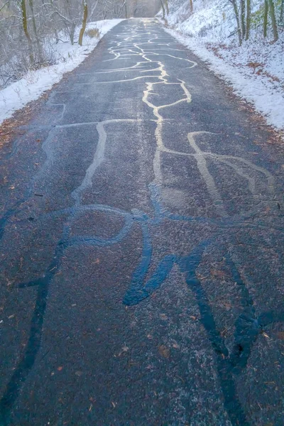 Cracked road on a hill covered with snow in winter