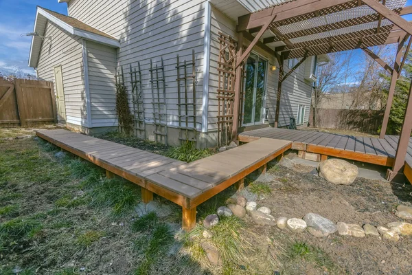 Exterior de una casa con una pasarela de madera y cubierta en el patio — Foto de Stock