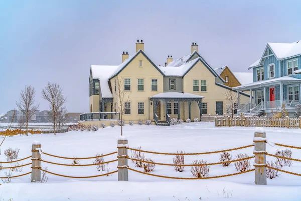 Adorables casas más allá de una valla de cuerda en el suelo cubierto de nieve en invierno — Foto de Stock