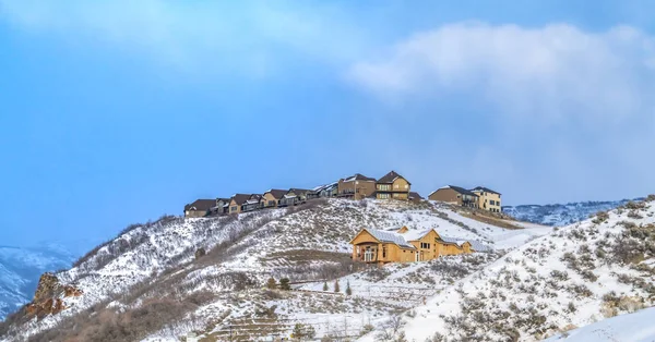 Belles maisons construites au sommet d'une montagne couverte de neige en hiver — Photo