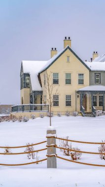 Kışın karla kaplı zemin üzerinde bir ip çit ötesinde Dikey Adorable evleri