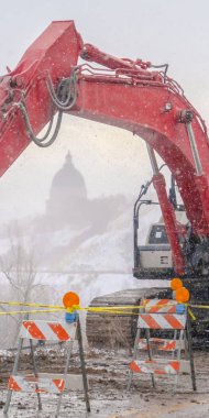 Arka planda Utah State Capital Building ile bir dağ yolu üzerinde Dikey Ekskavatör