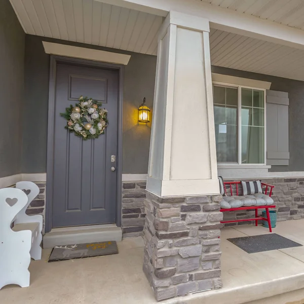 Vierkante grijze voordeur op de gevel van een huis versierd met bauble en bloem krans — Stockfoto
