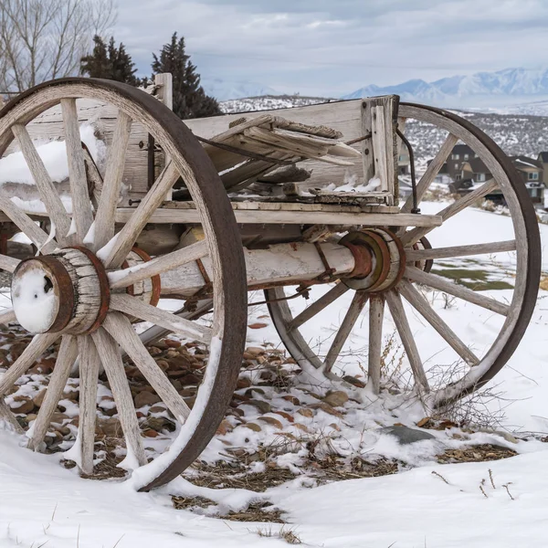 Vierkante verweerde wagon tegen een schilderachtig landschap bedekt met sneeuw in de winter — Stockfoto