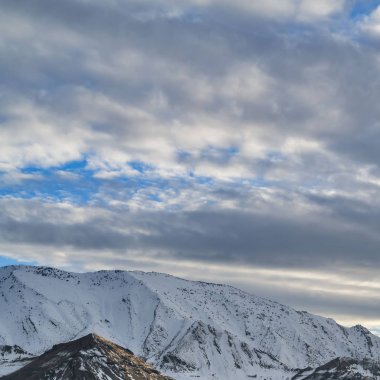 Kare Canlı mavi gökyüzü büyük bir dağın üzerinde kalın gri bulutlar ile dolu