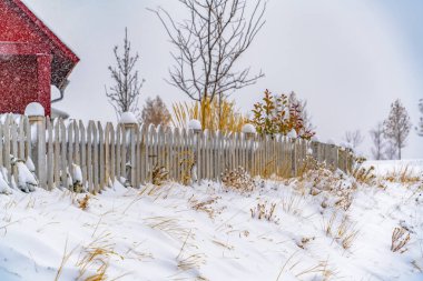 Kış manzarası, canlı kırmızı bir ev ve Şafak 'taki çitlerin tepesinde kar.