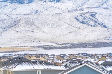 Kışın karla kaplı engebeli bir dağın tabanına yakın doğal kasaba