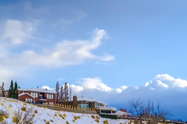 Casas en una colina nevada contra el impresionante cielo azul — Foto de Stock