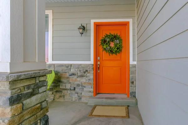 Casa con una corona de bienvenida colgando de la puerta delantera naranja — Foto de Stock