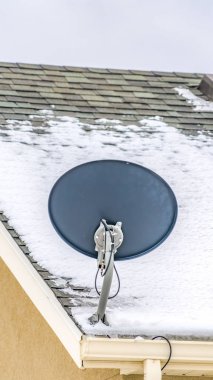 Çatı köşesinde küçük bir uydu anteni ile bir evin Dikey Dış görünümü