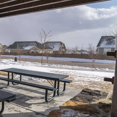 Güneşli bir kış gününde karlı bir parkta bir pavyon içinde Açık Kare Tablolar ve banklar