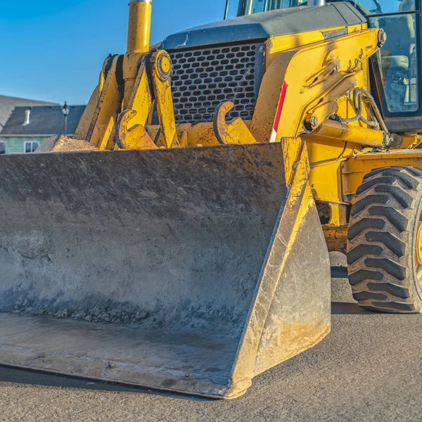 Fyrkantig närbild av en entreprenadmaskin parkerad på vägen på en solig dag — Stockfoto