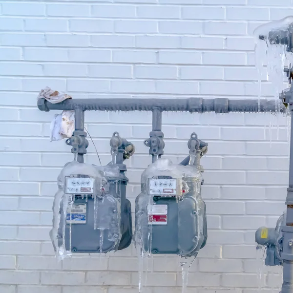 Square Water meters and pipes covered with ice during winter in Eagle Mountain