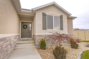 Çelenk ve yan ışık ile gri ön kapıya giden yol ve merdivenler