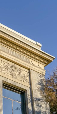 Güneşli bir günde berrak mavi gökyüzünü yansıtan cam pencereleri olan Dikey Bina