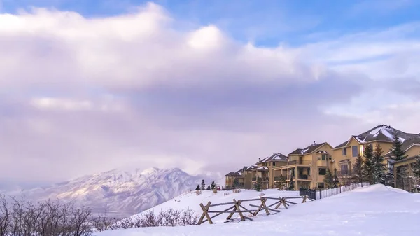 Clear Panorama Homes overlooking a scenic snow capped mountain and vivid blue sky with clouds — Stock Photo, Image