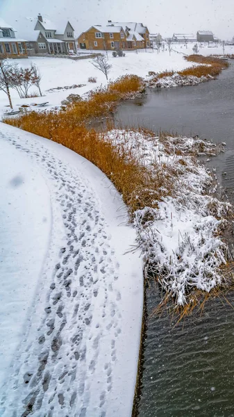 Clear Vertical Lago de invierno con marcas de pista en su orilla nevada — Foto de Stock